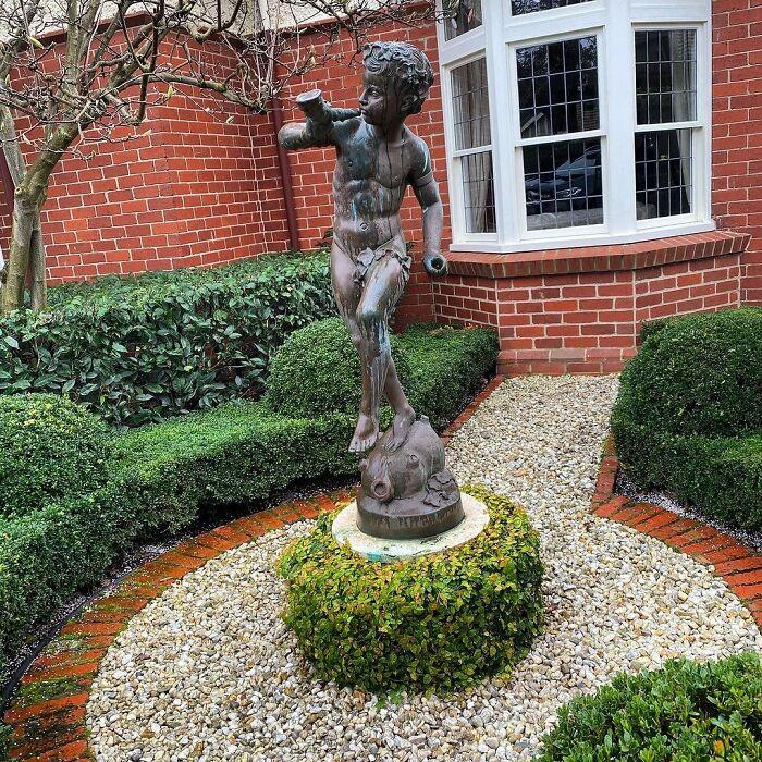 Create a focal point with ⁣an artistic front yard landscaping sculpture