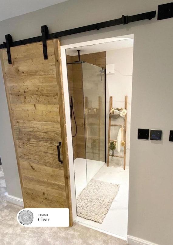 Reclaimed barn ⁢doors create charm in⁣ farmhouse bathrooms