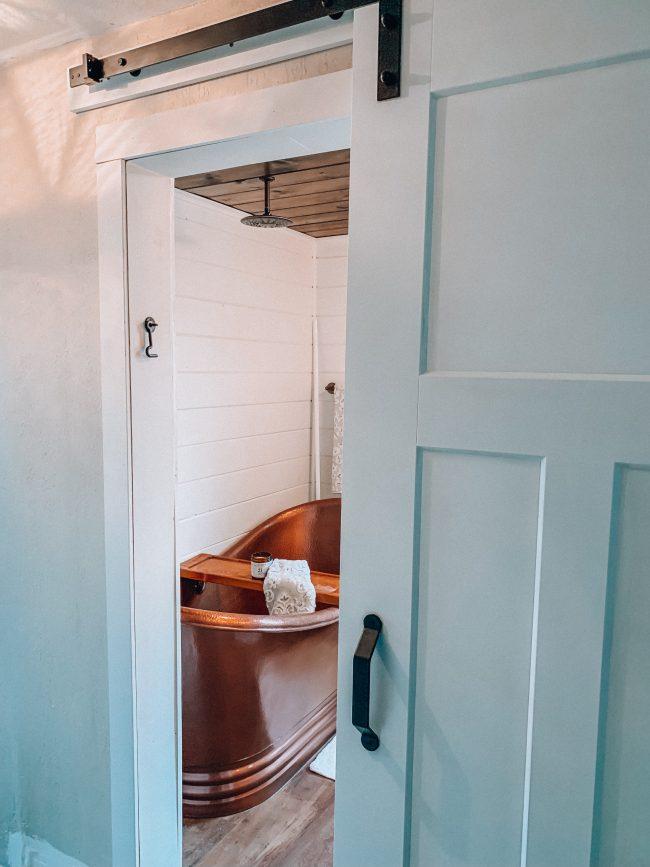 Sliding barn doors add charm and space ⁤in farmhouse bathrooms