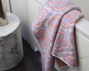 Layer different ​patterns in towels for an eclectic bathroom vibe