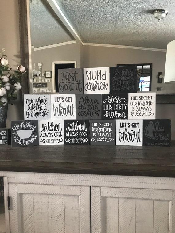 Decorative signs with farmhouse sayings add personality to your kitchen walls