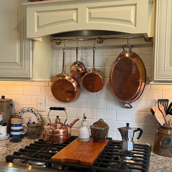 Maximize vertical space with wall-mounted racks for pots and pans in the kitchen