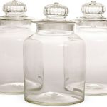 Unique trio of decorative glass jars with ornate lids .
