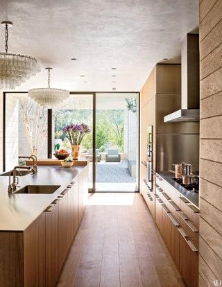 Natural light floods a farmhouse kitchen, brightening up workspaces and gathering areas