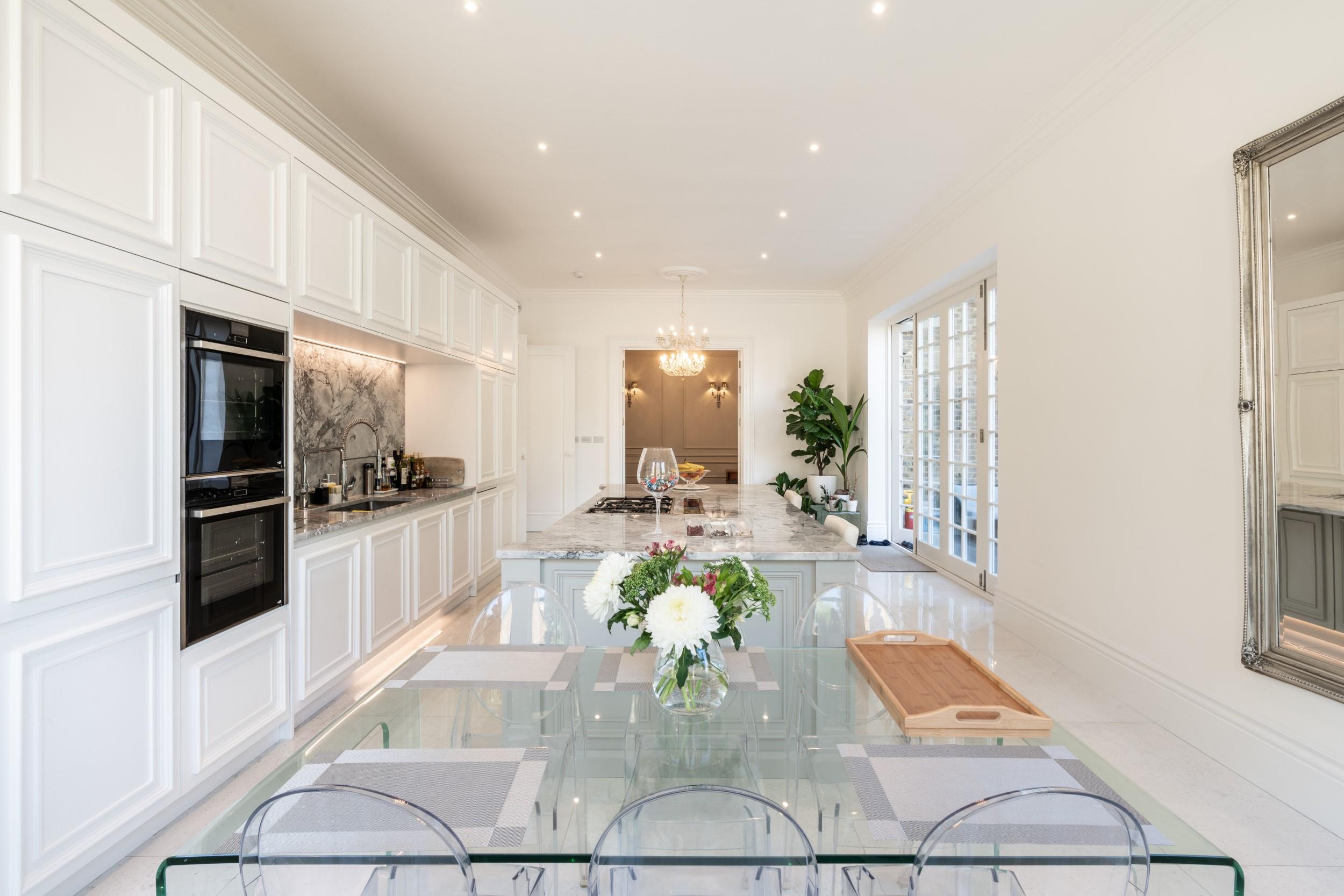 Hang a large mirror in your galley kitchen to reflect⁢ light and expand visuals