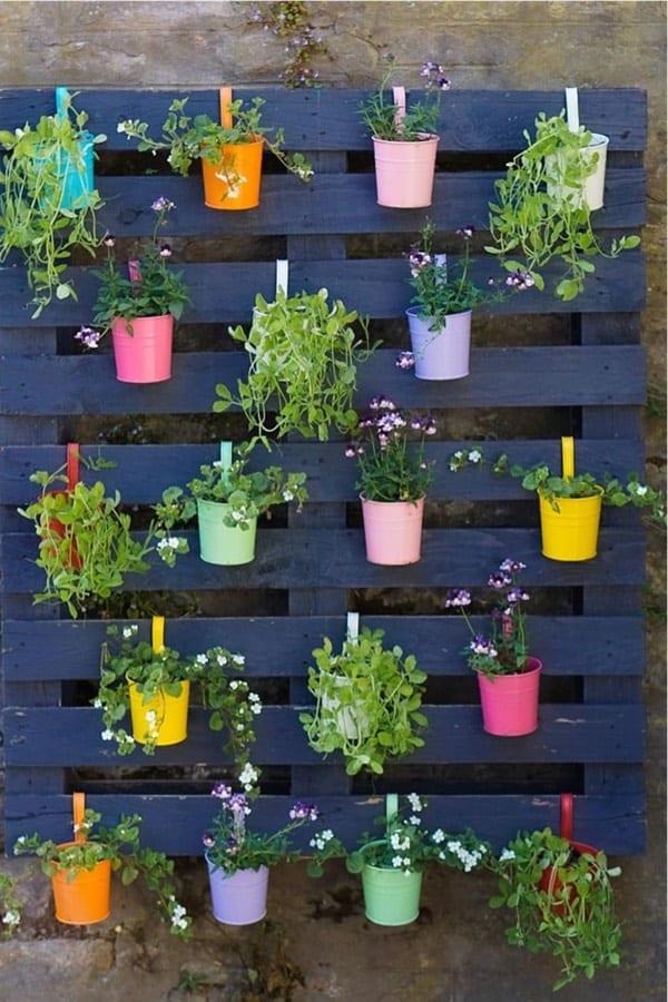 Use colorful paints ​to transform a simple pallet garden into a vibrant centerpiece